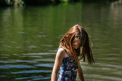 Rear view of girl wearing hat against lake