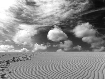 Scenic view of sand dune against sky