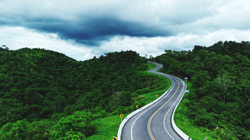 High angle view of road amidst trees against sky