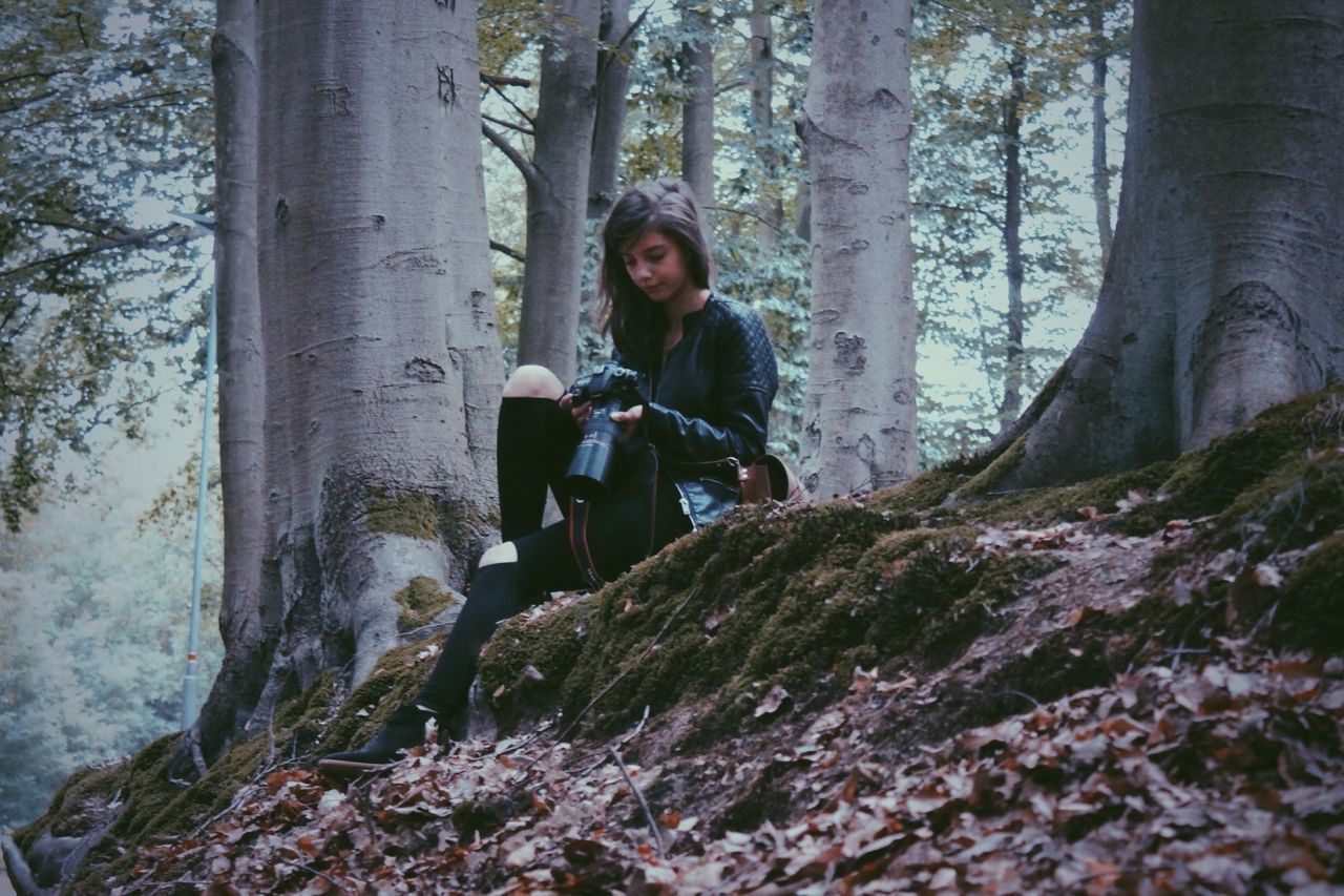 Young woman with camera in the forest