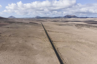Aerial view of a straight road crossing a desert valley near caleta de famara in lanzarote
