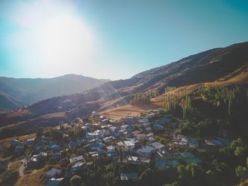 Aerial view of townscape and mountains against sky