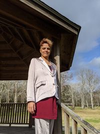 Portrait of smiling woman standing against sky