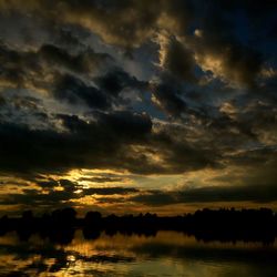 Scenic view of sea against cloudy sky at sunset