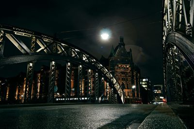 Arch bridge against sky in city at night