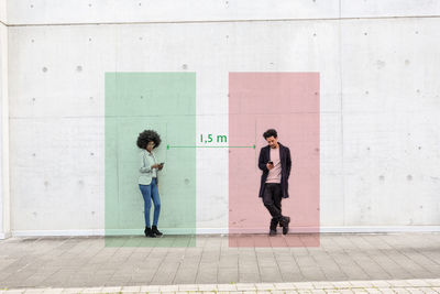 Full length of a woman standing against wall