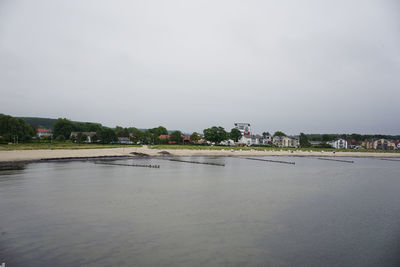 Scenic view of river by buildings against sky