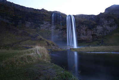 Scenic view of waterfall against sky