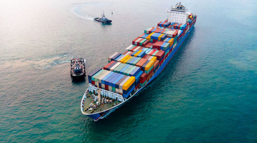 Aerial of cargo ship carrying container and running for export goods from cargo yard port to other 