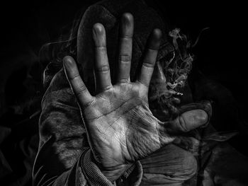 Close-up of human hand against black background