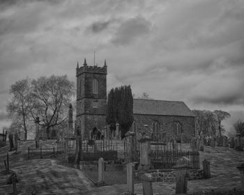 Church and cemetery against cloudy sky