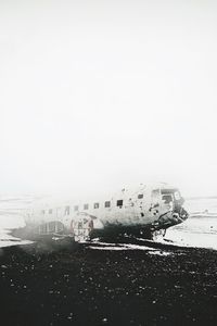 Cars on snow covered landscape against sky