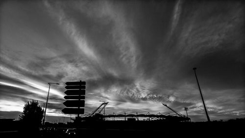 Low angle view of silhouette buildings against cloudy sky