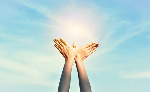Low angle view of woman hand against sky