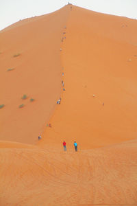 People on sand dune at desert