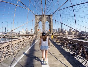 Rear view of young woman on suspension bridge