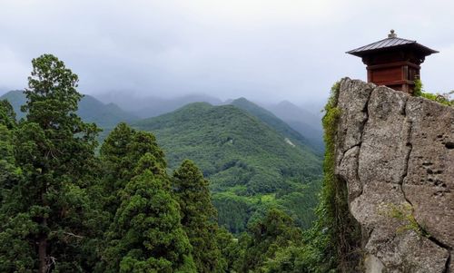 Scenic view of trees and mountains against sky