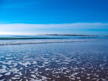 Scenic view of sea against blue sky