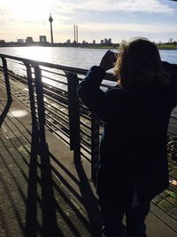 People looking at river in city