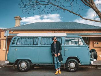 Full length of man standing on car against sky