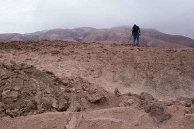 Man standing on mountain against sky