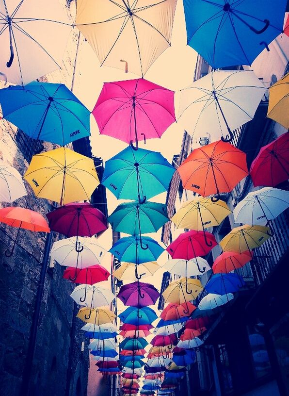 low angle view, multi colored, architecture, built structure, hanging, umbrella, building exterior, decoration, sky, clear sky, colorful, protection, flag, day, pattern, full frame, no people, outdoors, backgrounds, roof