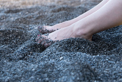 Low section of woman on black sand beach