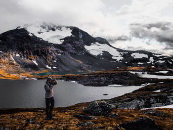 Man photographing on mountain during winter