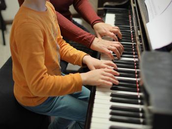 Midsection of man playing piano