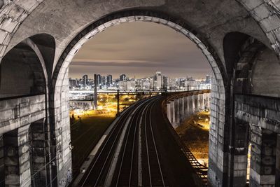 Archway of hell gate bridge in illuminated city