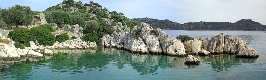 Panoramic view of rocks in sea against sky