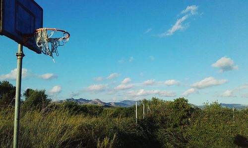Basketball hoop on field against sky