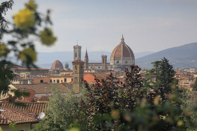 Panoramic view of buildings and trees against sky in city