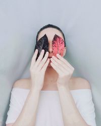 Woman covering face with leaves