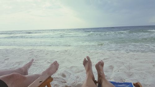 Low section of man relaxing on beach