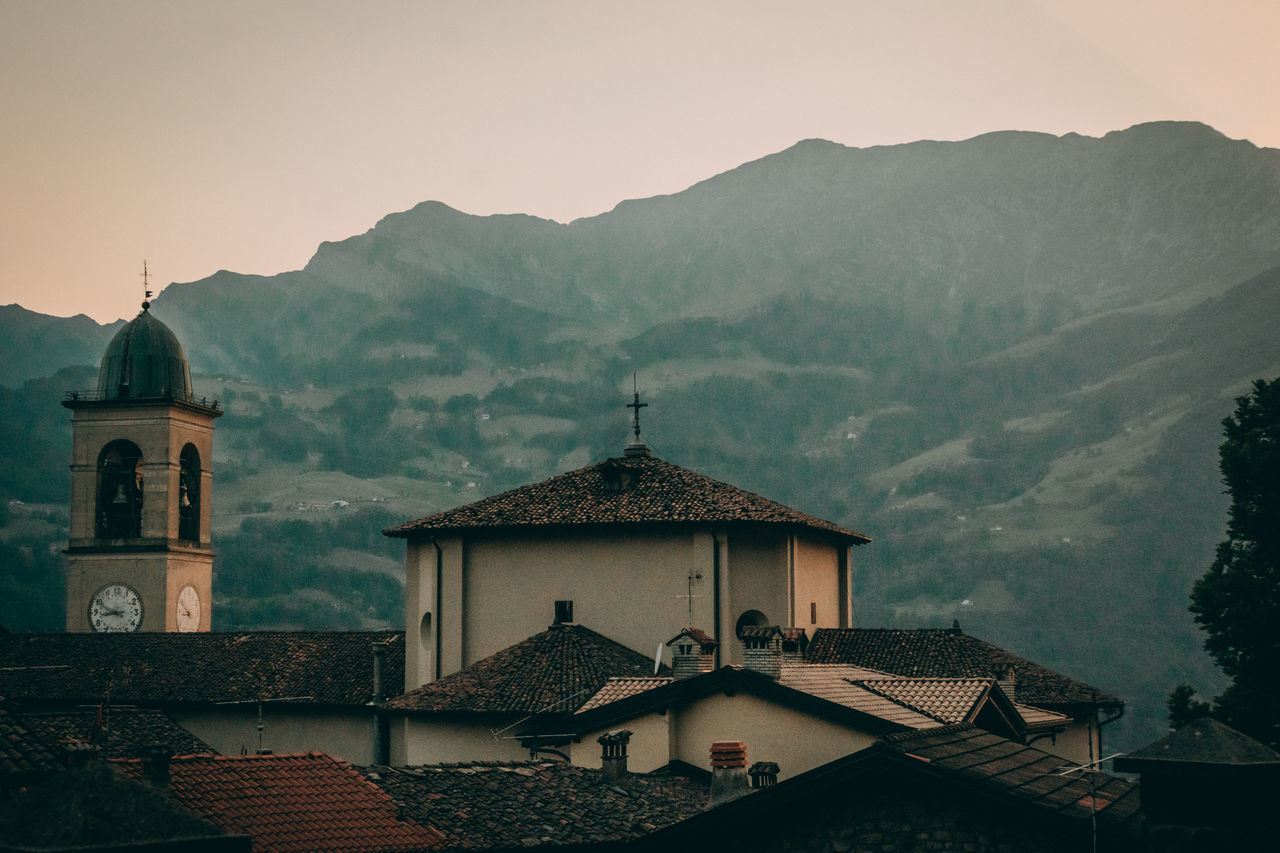 HOUSES AGAINST SKY AND BUILDINGS IN MOUNTAINS