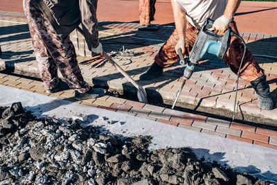 Low section of man working on footpath