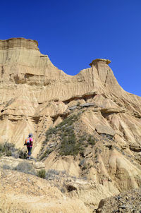 Rear view of rock formations against clear blue sky