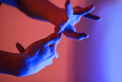Cropped hands of person gesturing in illuminated room