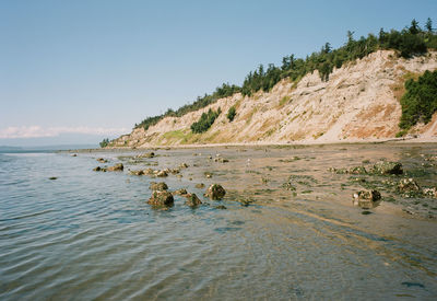 Scenic view of sea and mountains against clear sky