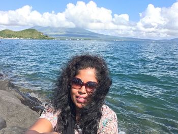 Woman wearing sunglasses against sea