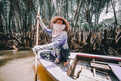 Full length of woman standing on tree trunk