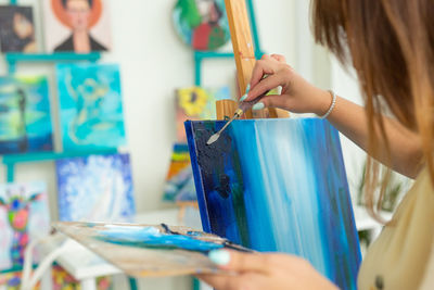 Midsection of woman painting at home