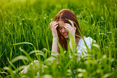 Young woman sitting amidst plants