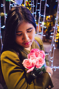 Close-up of young woman blowing flowers