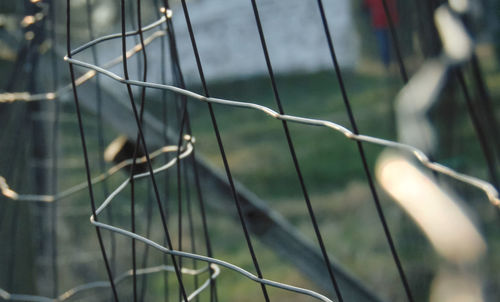 Close-up of barbed wire fence on field