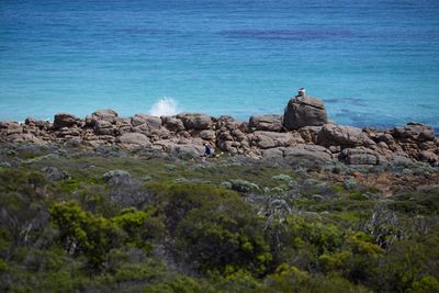 Rock formation on beach against blue sky