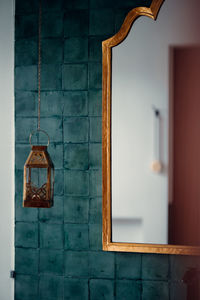 Close-up of electric lamp hanging on wall of building