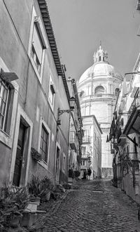 Alley amidst buildings in city against sky