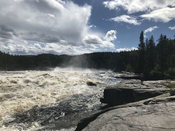 Scenic view of waterfall against sky